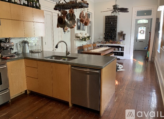 A kitchen with wooden cabinets and a stainless steel dishwasher.
