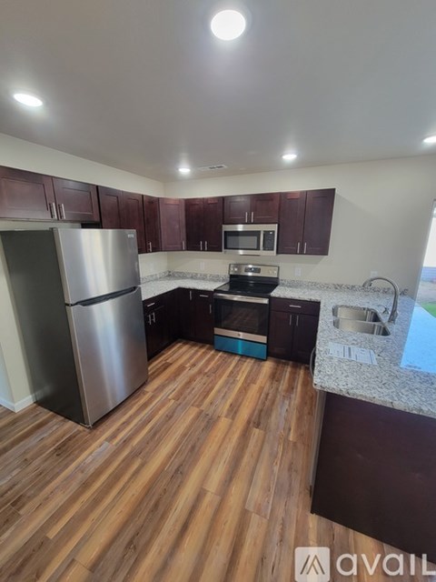 A kitchen with wooden floors and stainless steel appliances is available for rent.