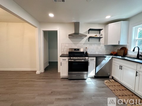 A modern kitchen with white cabinets and stainless steel appliances.