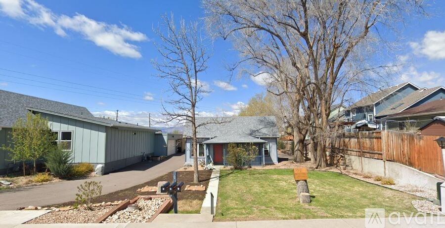 A sunny day in a residential area with houses and trees.