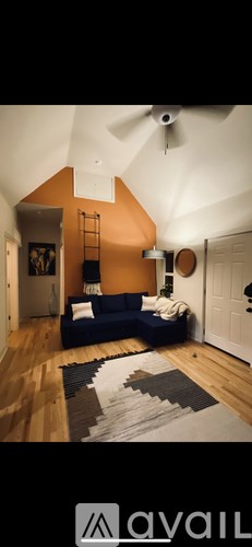 A living room with a blue sofa and a fan on the ceiling.