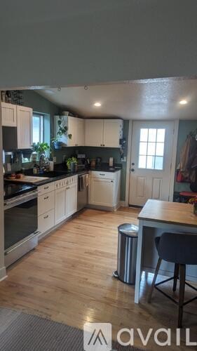A kitchen with wooden floors and white cabinets.