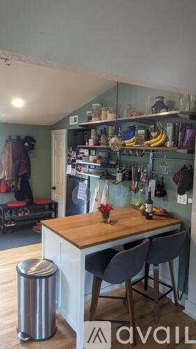 A kitchen with a table and chairs in the foreground and a pantry in the background.