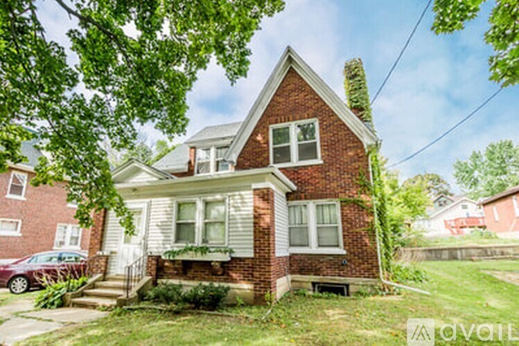 A house with a red brick facade and a white porch.