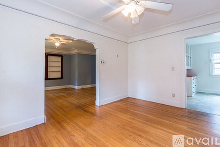 A room with wooden floors and a ceiling fan.