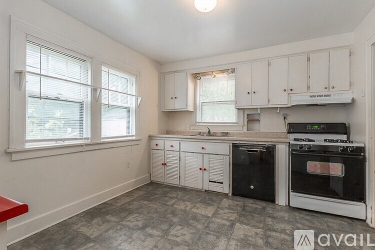 A kitchen with black appliances and white cabinets.