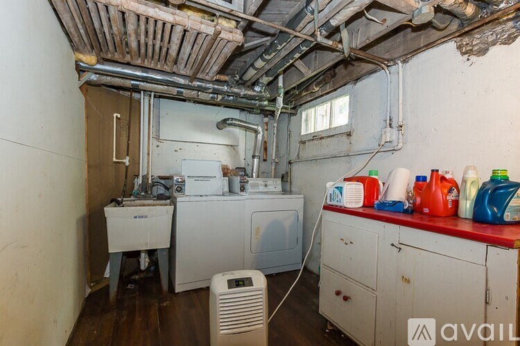 A laundry room with a washer and dryer, a fan, and a red counter.