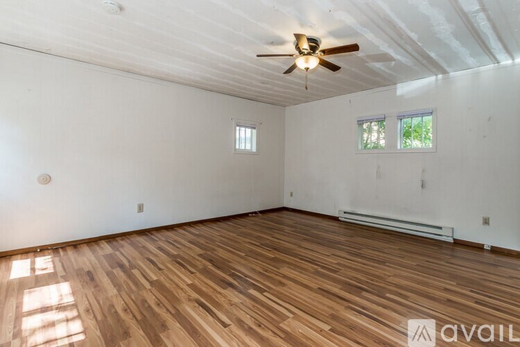 A room with wooden flooring and a ceiling fan.