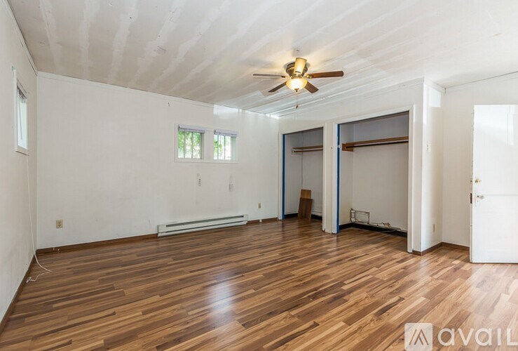 A room with wooden floors and a ceiling fan.