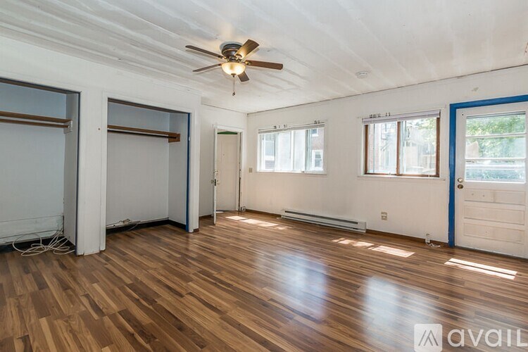 A room with wooden floors and a ceiling fan.