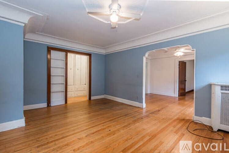 A room with wooden floors and a white ceiling fan.