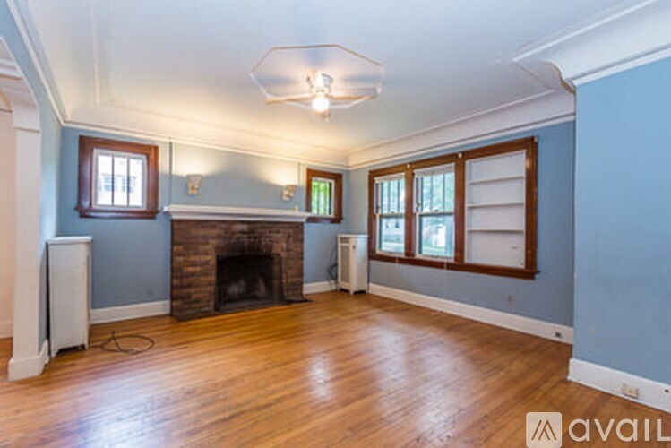 A room with a fireplace and wooden floors.