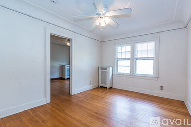 A room with a ceiling fan and a window.