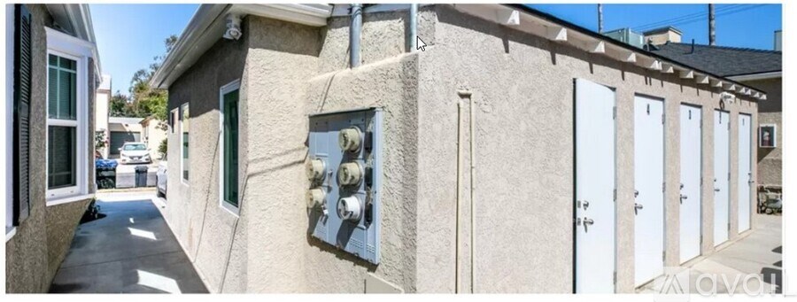 A row of white doors are on the side of a building.