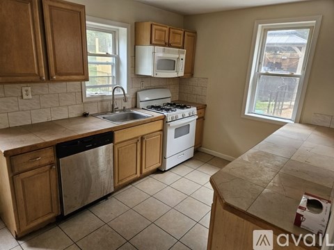 A kitchen with wooden cabinets and a white stove top oven.