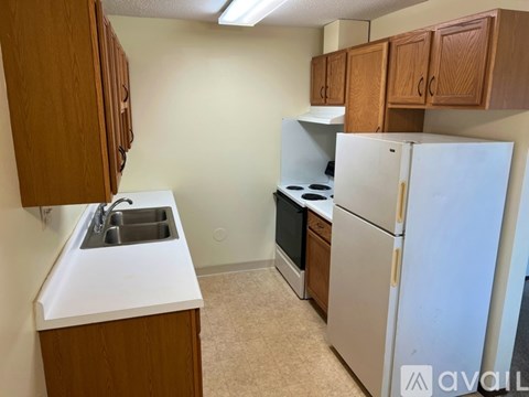 A kitchen with a sink, stove, and refrigerator.
