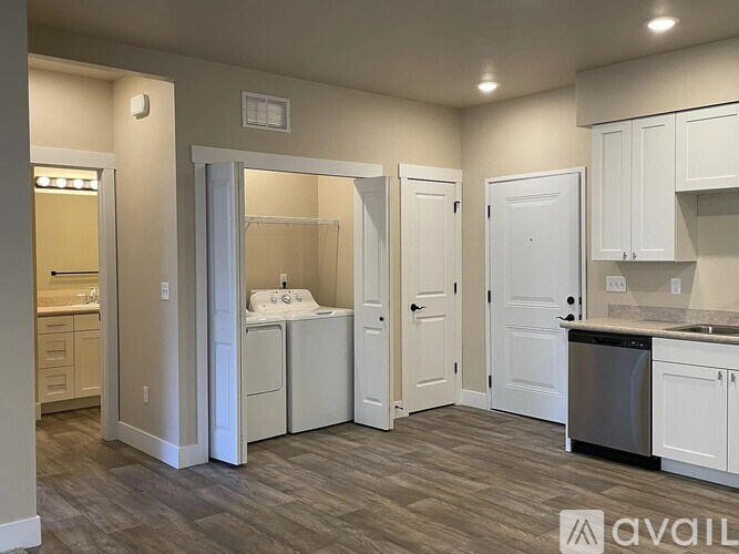 A kitchen with white cabinets and a wooden floor.