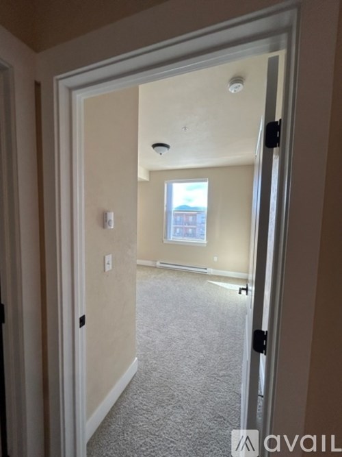 A room with a carpeted floor and a window.