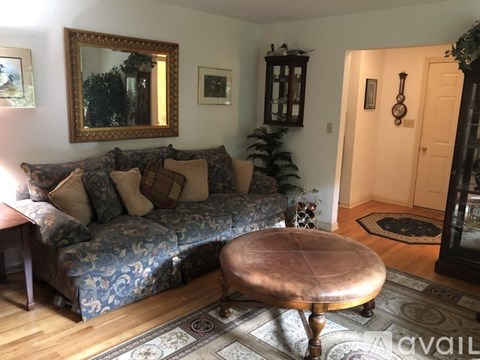 A living room with a blue patterned couch and a wooden coffee table.