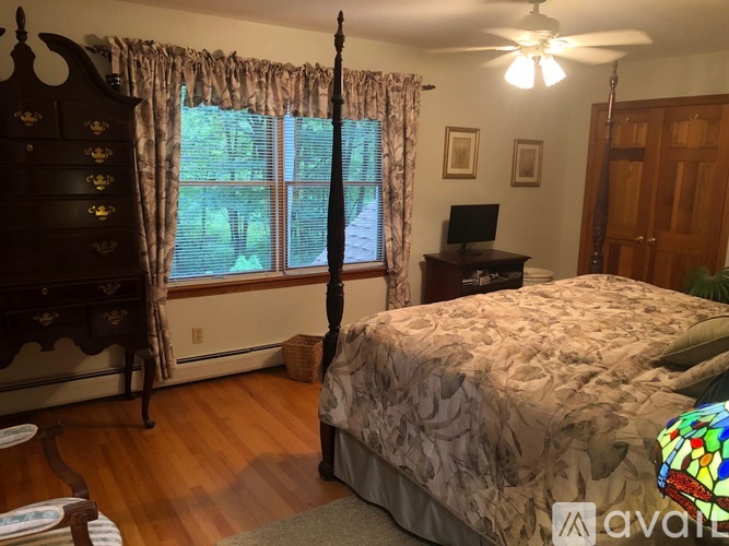 A bedroom with a large bed and a dresser.