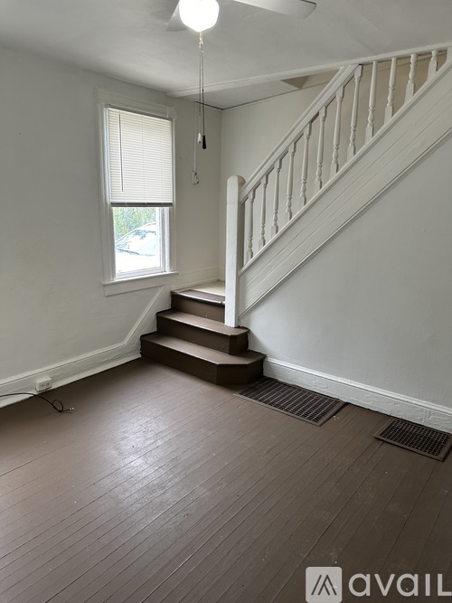 A room with a staircase and wooden flooring.