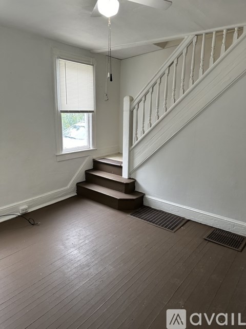 A room with a staircase and wooden flooring.