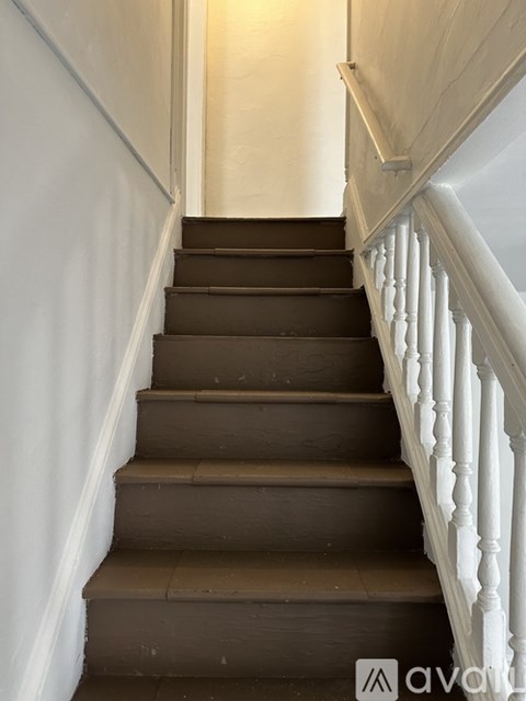 A staircase with white balusters and brown steps.