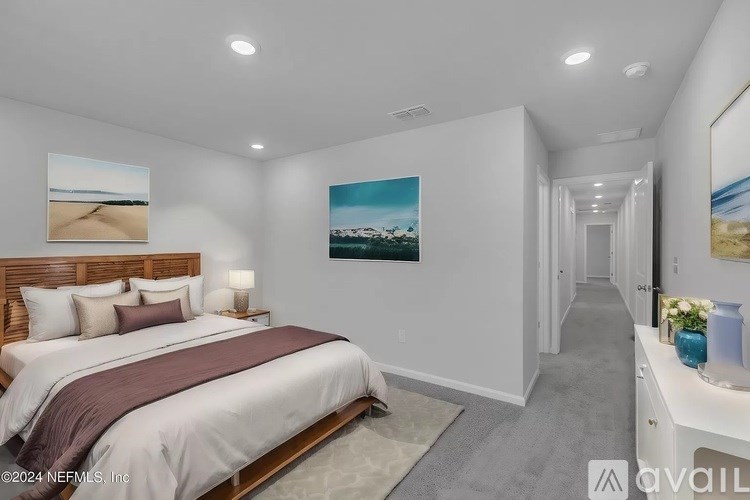 A bedroom with a large bed and a painting on the wall.