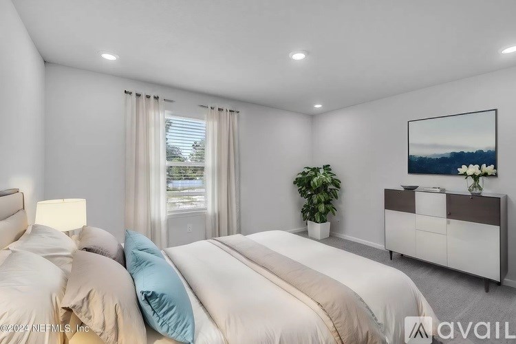 A bedroom with a large bed, a nightstand, and a painting on the wall.