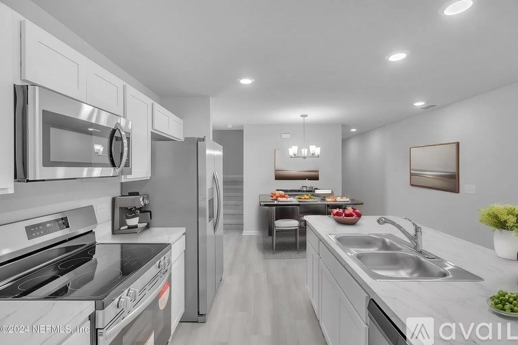 A modern kitchen with stainless steel appliances and a dining table set for two.