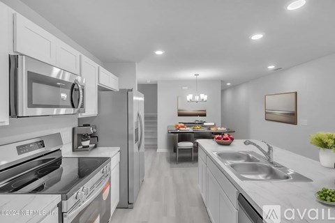 A modern kitchen with stainless steel appliances and a dining table set for two.