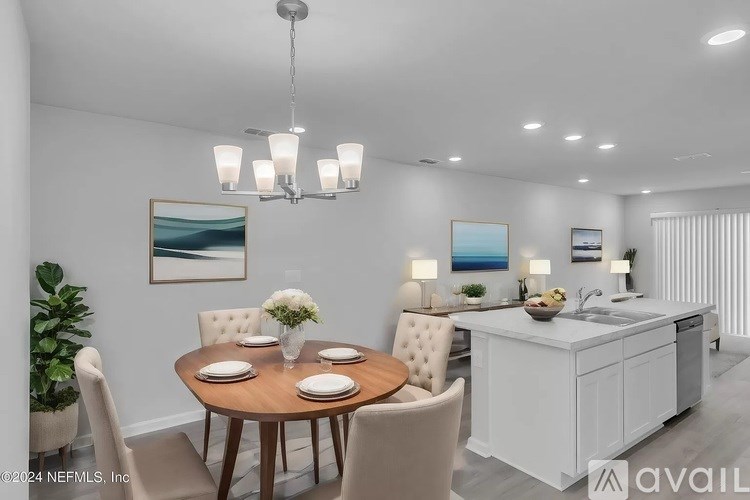 A modern dining room with a round table set for four.