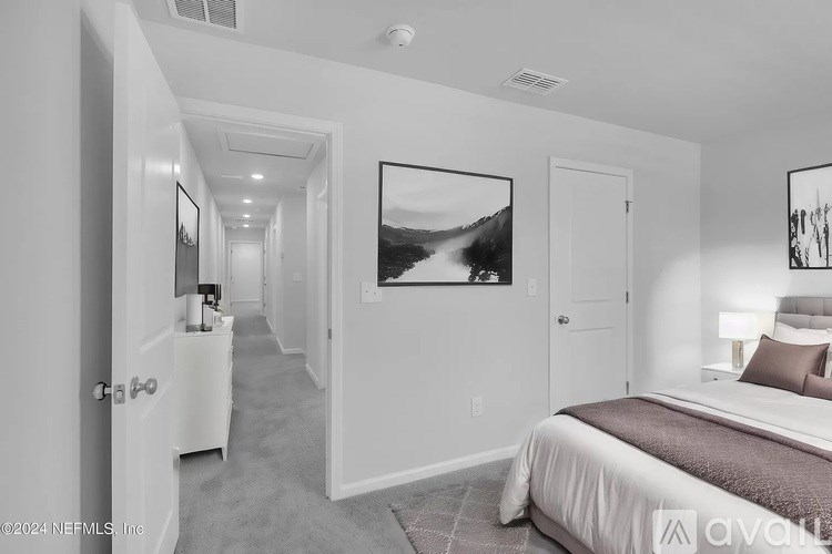 A bedroom with a bed, a nightstand, and a painting on the wall.