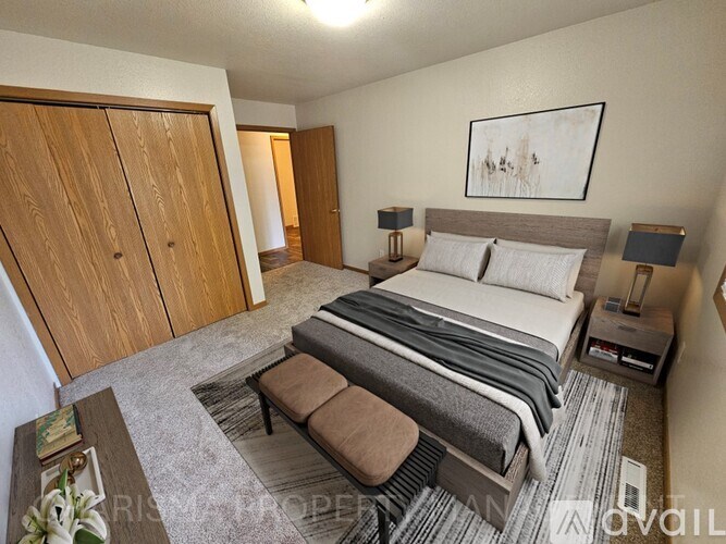 A bedroom with a large bed and a wooden wardrobe.