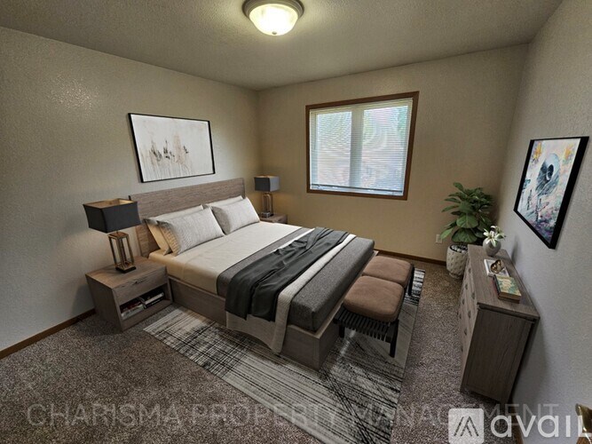 A bedroom with a bed, nightstand, and window.