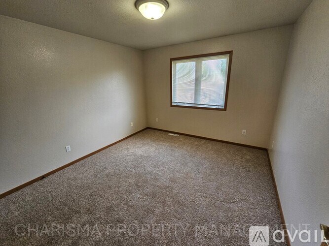 A room with a window and carpeted floor.