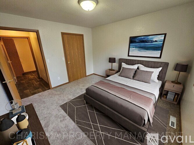 A bedroom with a bed, nightstands, and a painting on the wall.