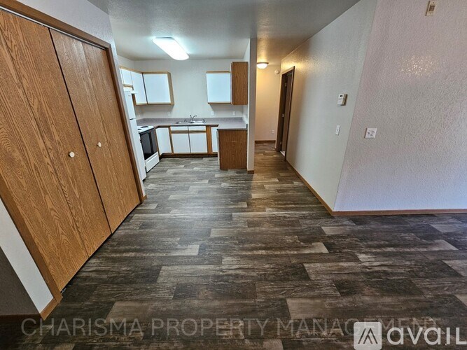 A kitchen area with wooden cabinets and a tiled floor.