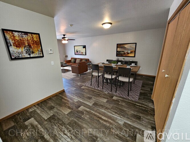 A living room with a couch, chairs, and a dining table.
