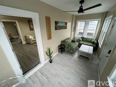 A living room with a couch, chair, and a cactus.