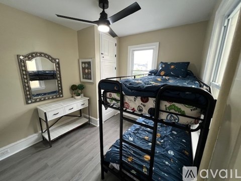 A bedroom with a bunk bed and a desk with a mirror on the wall.
