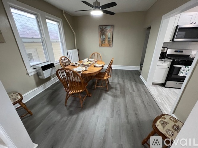 A dining room with a wooden table and chairs.