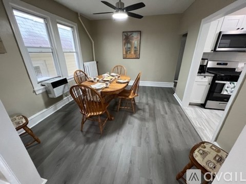 A dining room with a wooden table and chairs.