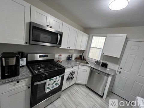 A kitchen with white cabinets and a black stove top.