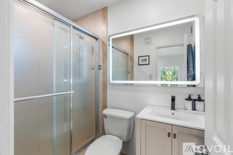 A modern bathroom with a toilet, sink, and mirror.