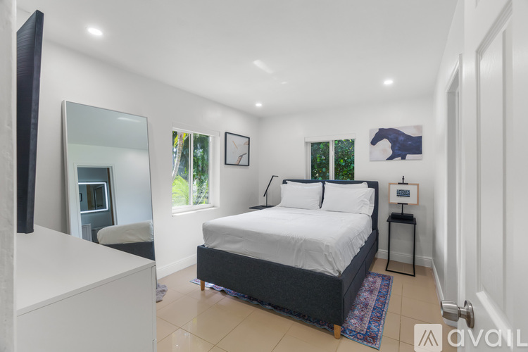 A bedroom with a large bed and a mirror on the wall.