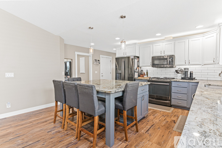 A kitchen with a table and chairs in front of it.