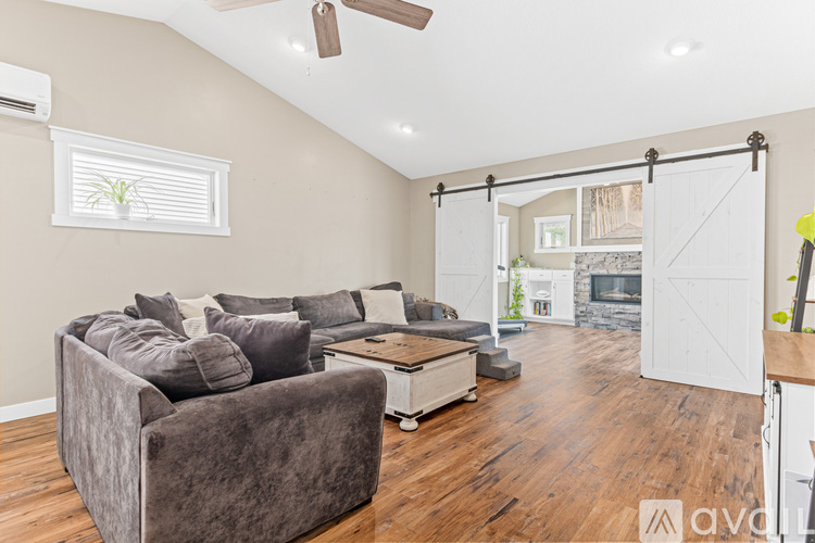A living room with a grey couch and a wooden floor.