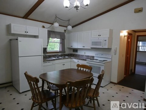 A kitchen with a table and chairs.