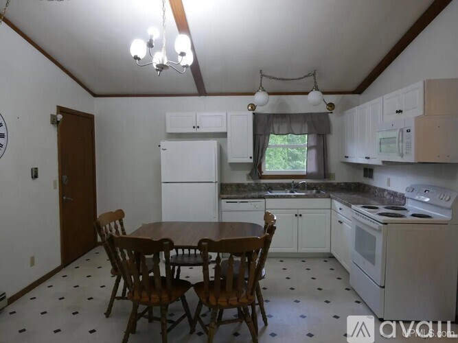 A kitchen with a table and chairs.